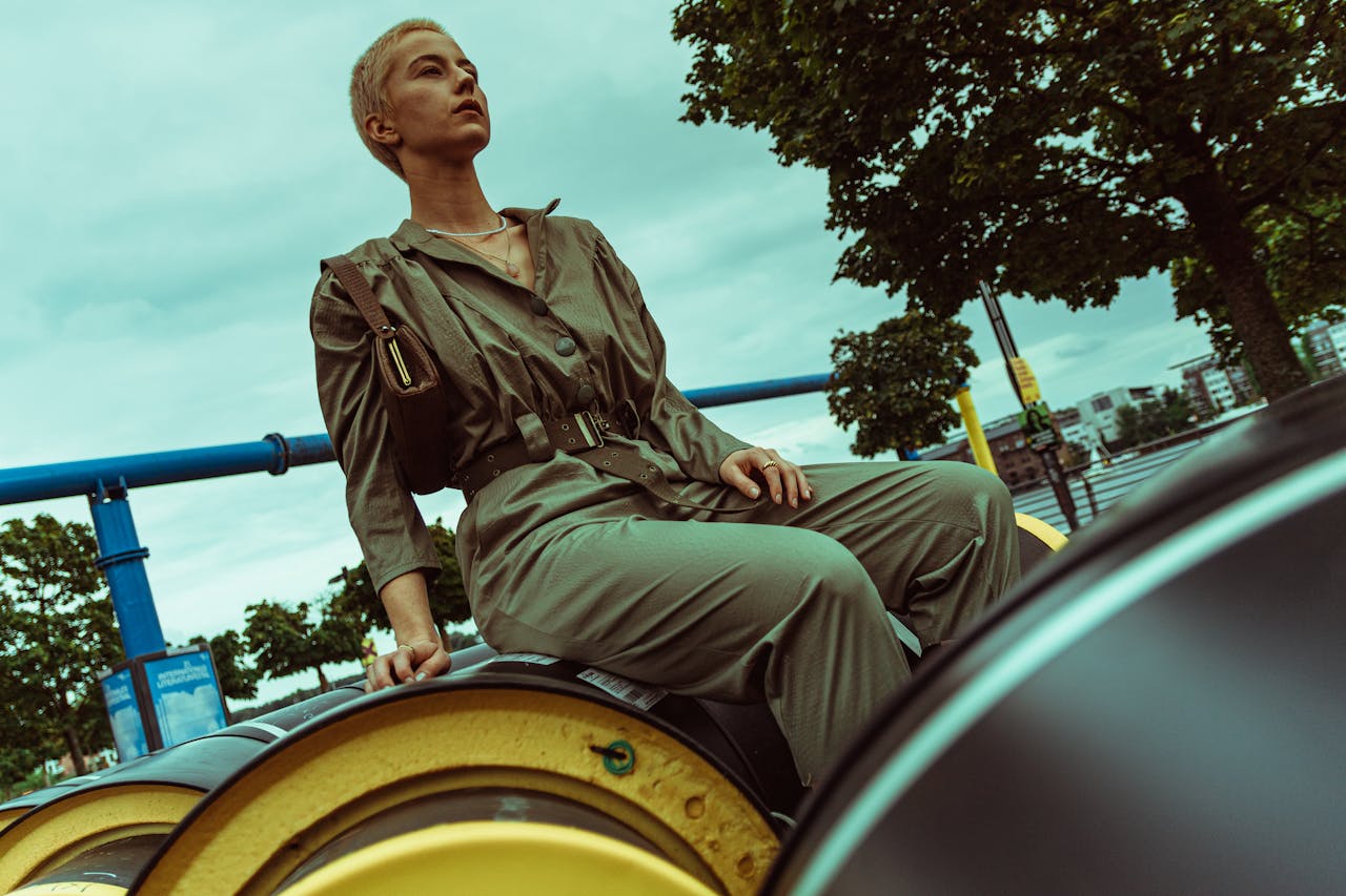 Fashion model in a jumpsuit sitting outdoors in Berlin, Germany. Stylish and contemporary.